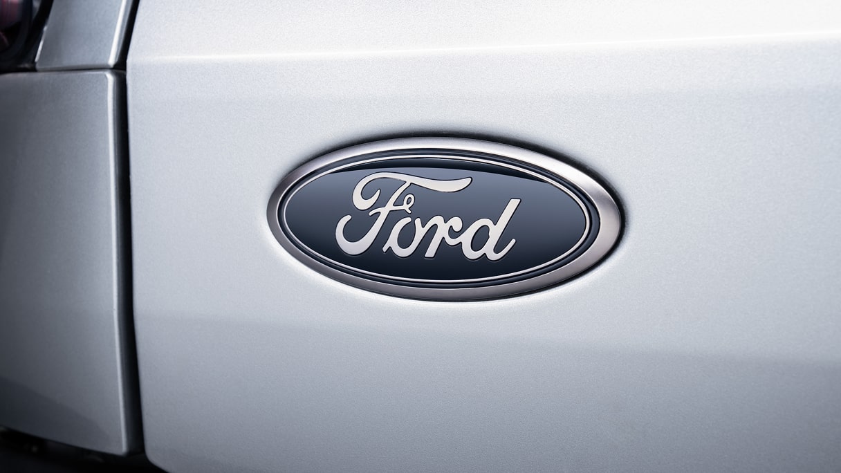 A close up of the Ford emblem on a white Ford vehicle.