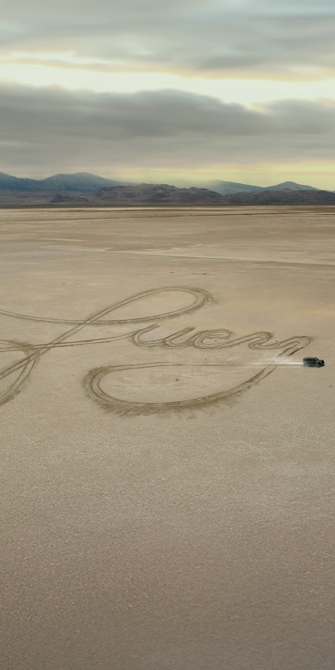 Un vehículo Ford traza el nombre "Lucy" en huellas de neumáticos sobre un salado, arriba de la oferta "Sign with Confidence".