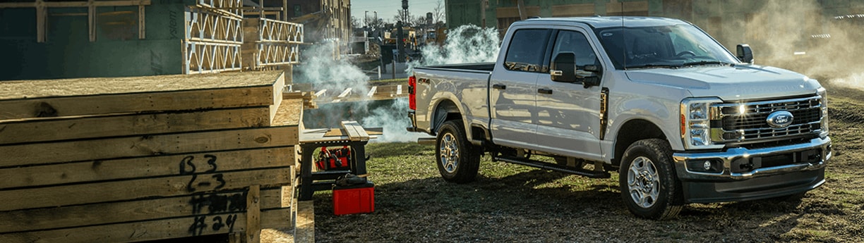 Ford truck parked in an outdoor setting with text overlay reading 'If You Clock in for America, You Should Pay What We Pay.'