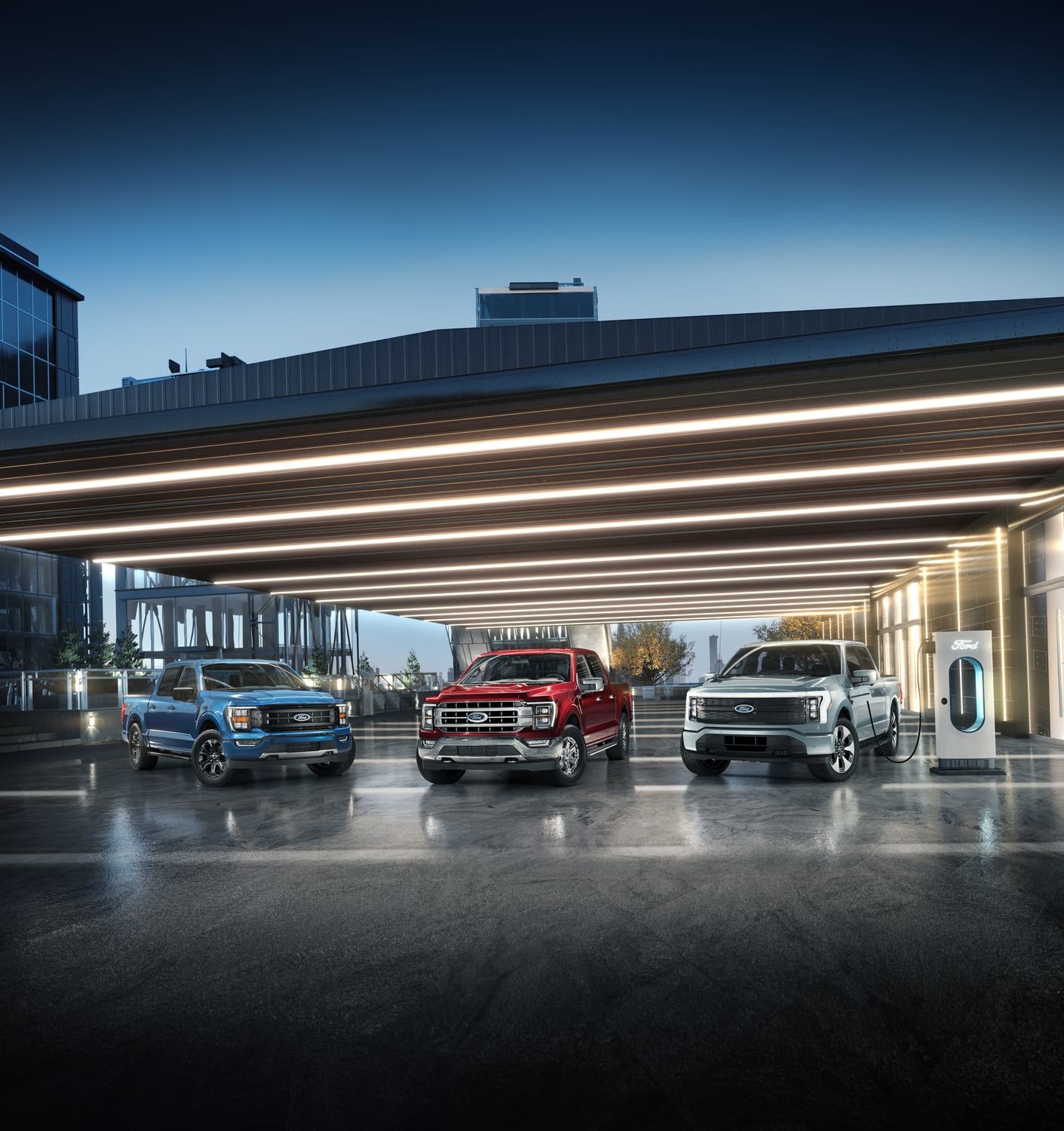 Three Ford trucks parked under a well-lit garage with one plugged into an EV charger.