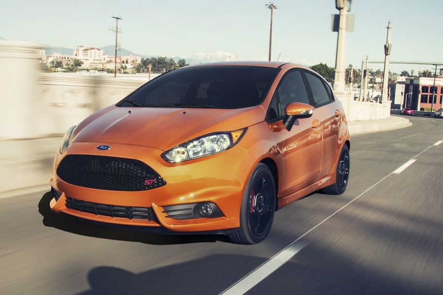 Three quarters shot of a Ford Fiesta G T in Orange Spice driving down a city road