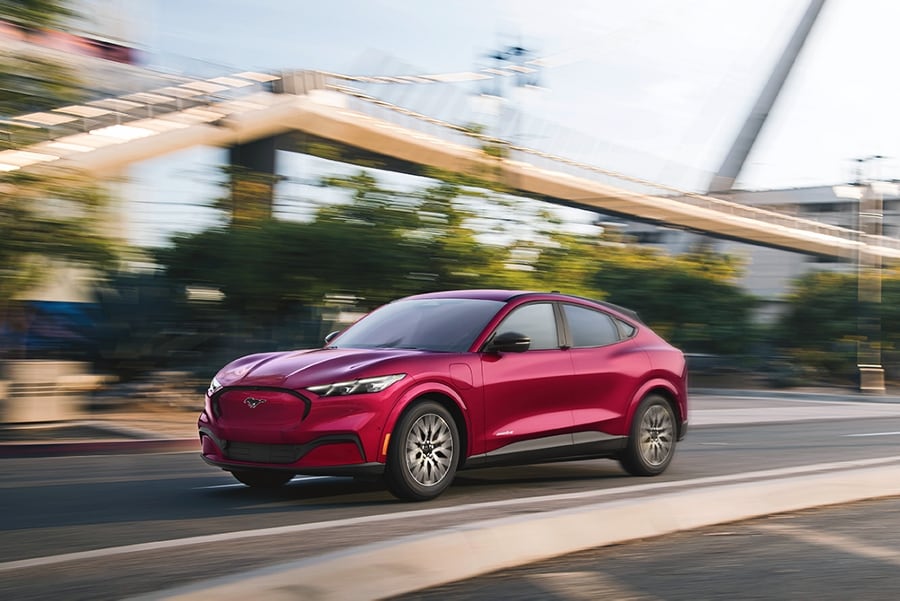 A 2025 Ford Mustang Mach-E driving on a city street