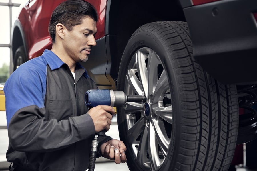 Ford Dealer Technician replacing a tire at the dealership