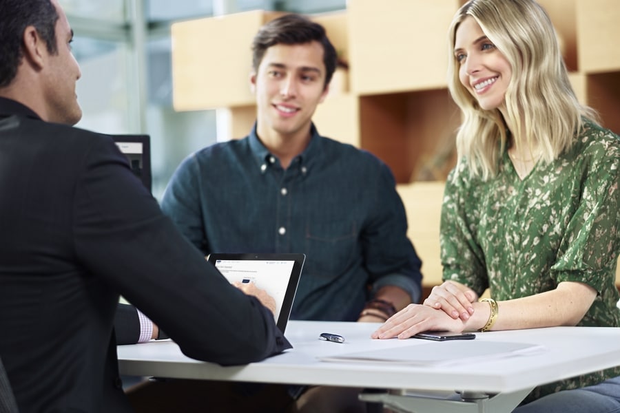A couple talking to a salesperson at the dealership