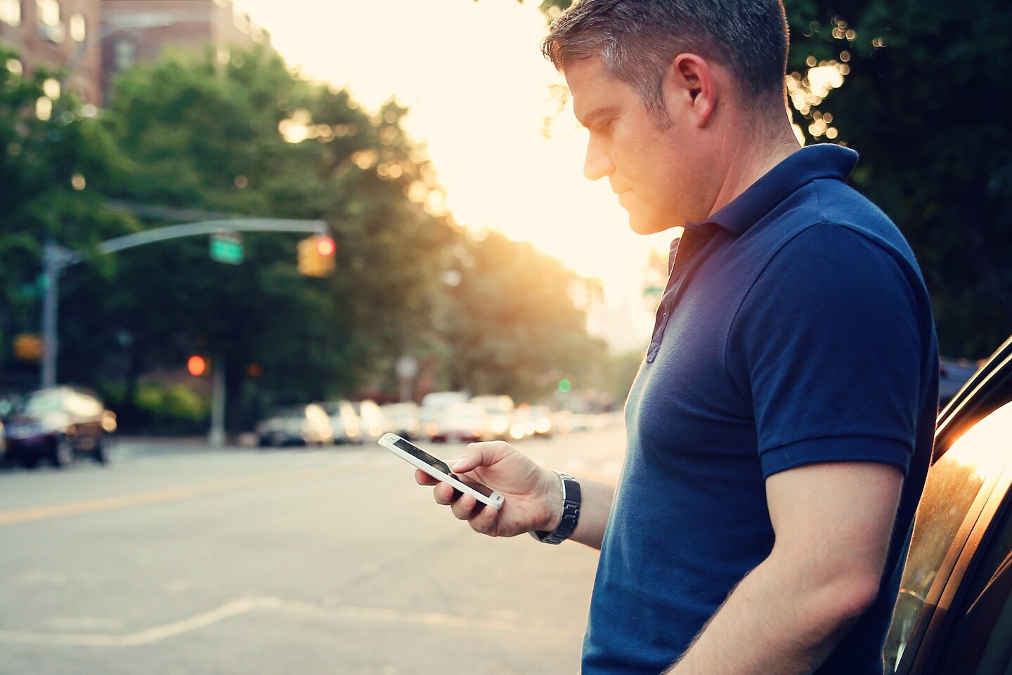 Person on their phone standing outside a parked Ford vehicle