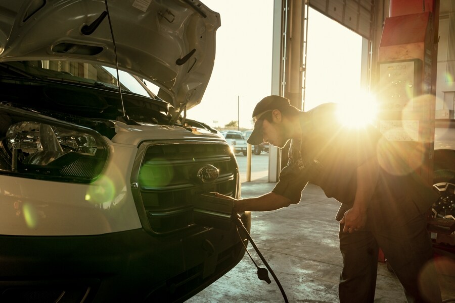 Técnico de servicio instalando un cable de carga en una van Ford E-Transit™ 2023