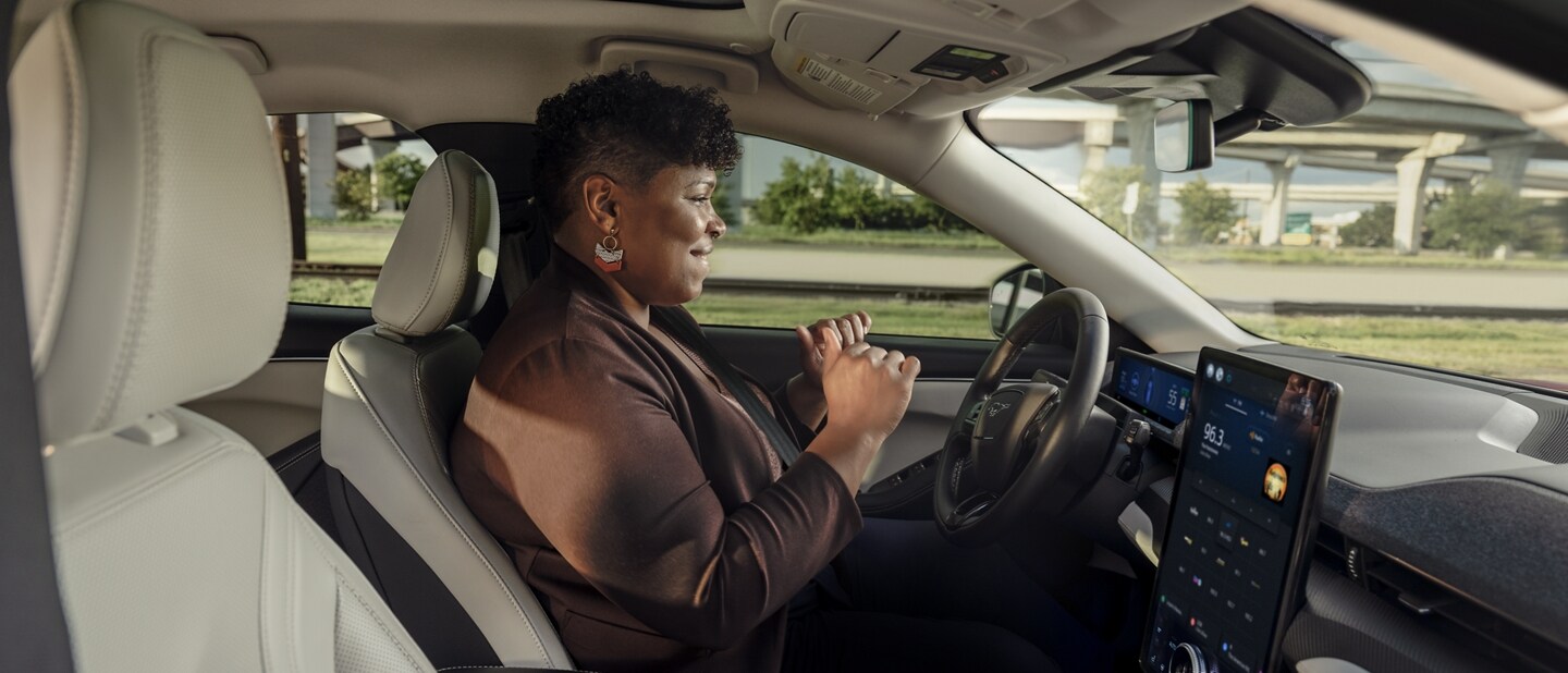 A woman in a 2023 Ford Mustang Mach-E® using Ford BlueCruise