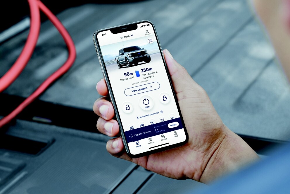 Un hombre viendo la aplicación FordPass® en su smartphone