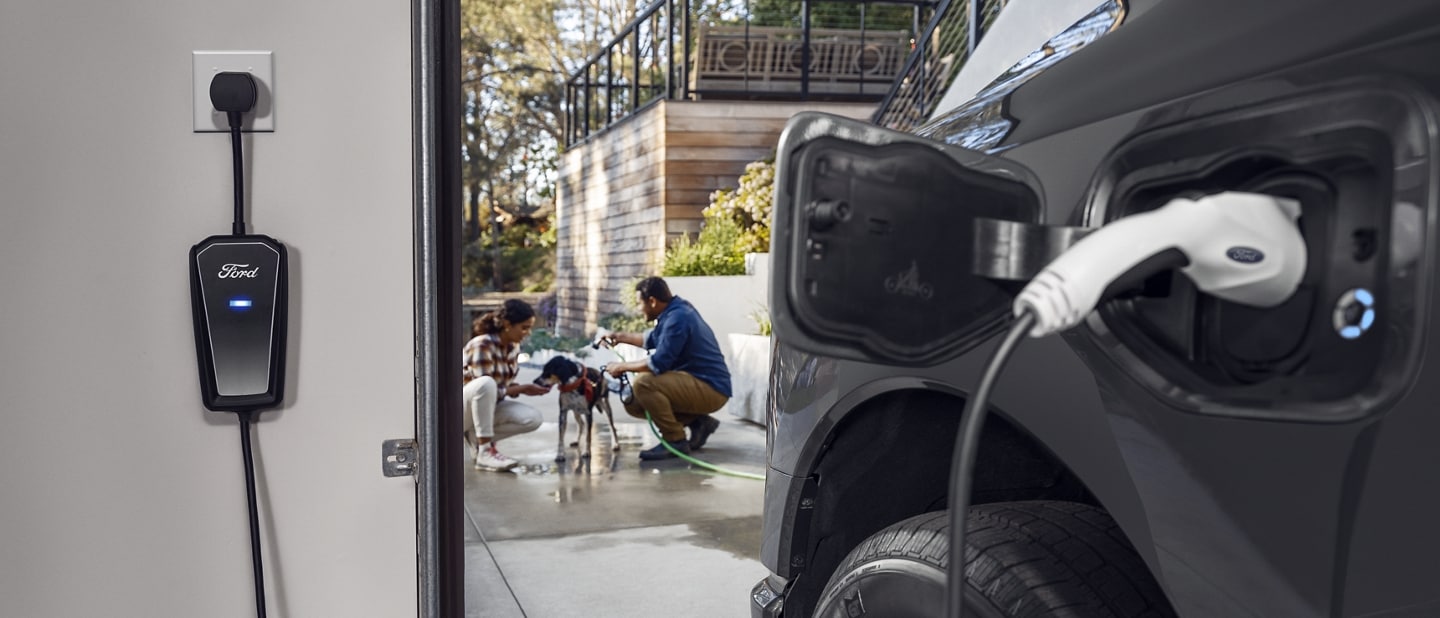 Close up of a 2023 Ford F-150® Lightning® charging port as it charges in a garage