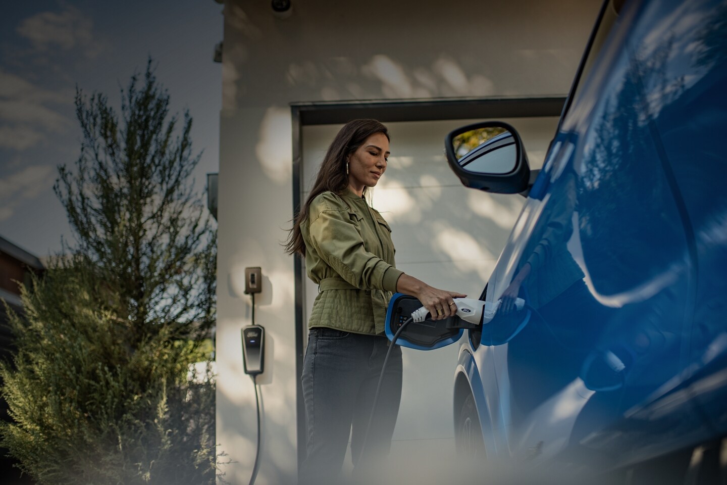 A woman begins to charge a 2023 Ford Mustang® Mach-E® at her home