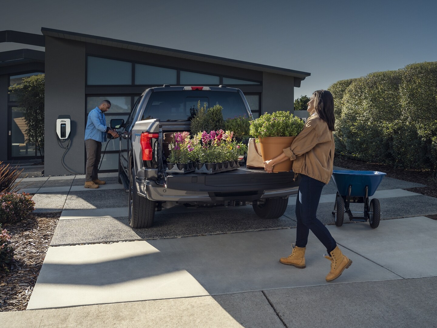 A woman unloading flowers from the bed of a 2023 Ford F-150 Lightning®