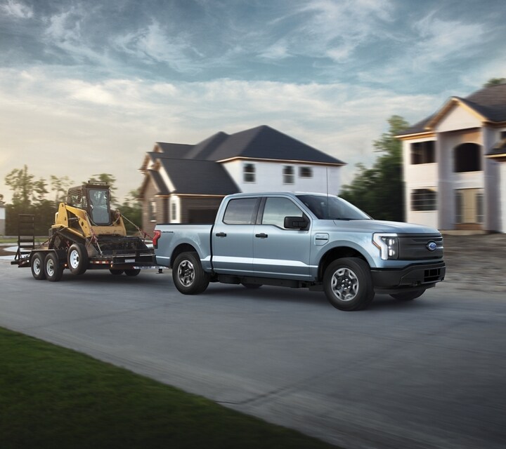 A silver 2023 Ford F-150® Lightning® parked in front of a home construction site
