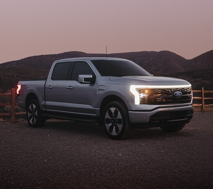 A 2023 Ford F-150® Lightning® parked in a desert-like landscape at dusk