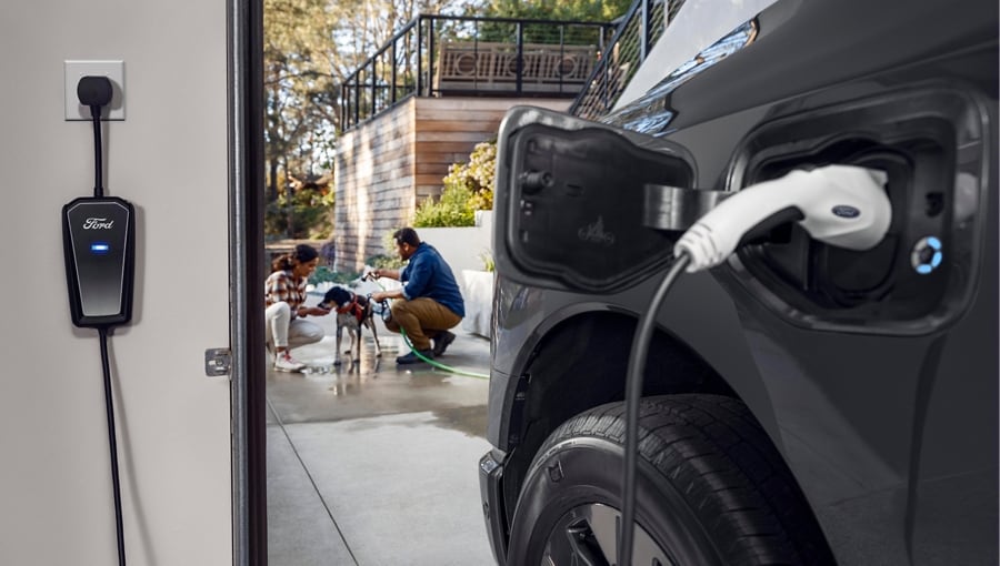 Closeup of a 2023 Ford F-150® Lightning® plugged into a home charging port