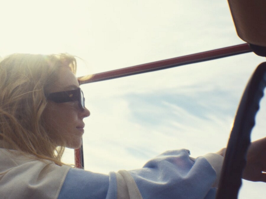 Actress Sydney Sweeney wears sunglasses as she drives her vintage Ford Bronco with the top removed on a sunny day