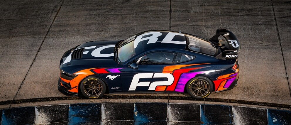 Ford Mustang® GT4 race car being driven around a curve on a closed course