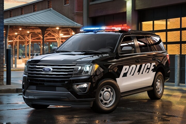The twenty twenty one ford expedition special service vehicle in front of a city garage