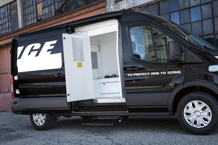 An open door reveals a side prisoner compartment of the twenty twenty ford transit prisoner transport vehicle 