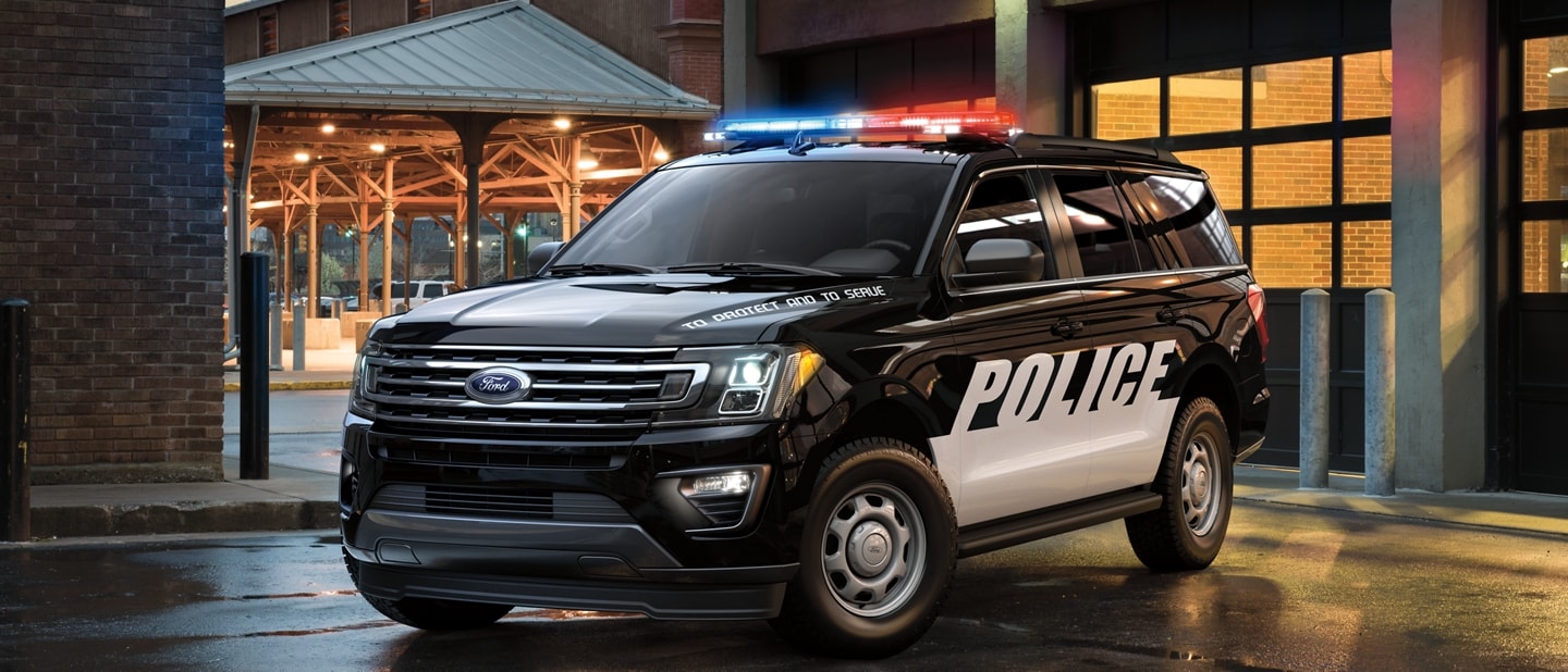 The twenty twenty one ford expedition special service vehicle in front of a city garage