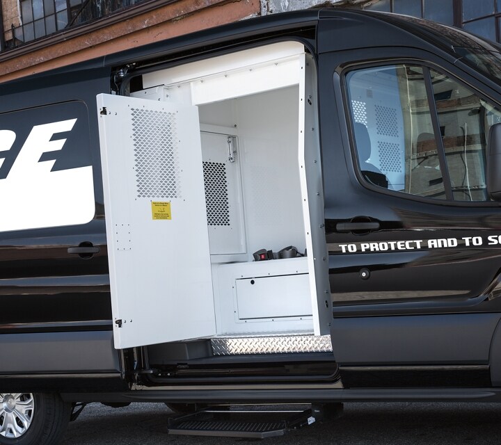 An open door reveals a side prisoner compartment of the twenty twenty ford transit prisoner transport vehicle 