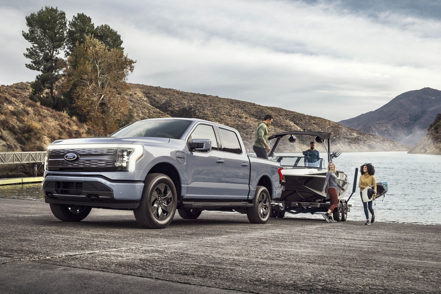 A 2023 Ford F-150® Lightning™ truck backing a boat into the water