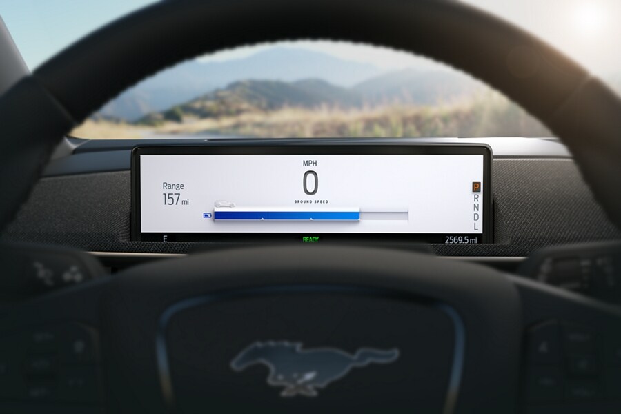 Closeup of a 2022 Ford Mustang Mach-E steering wheel and instrument cluster screen displaying charge status and range