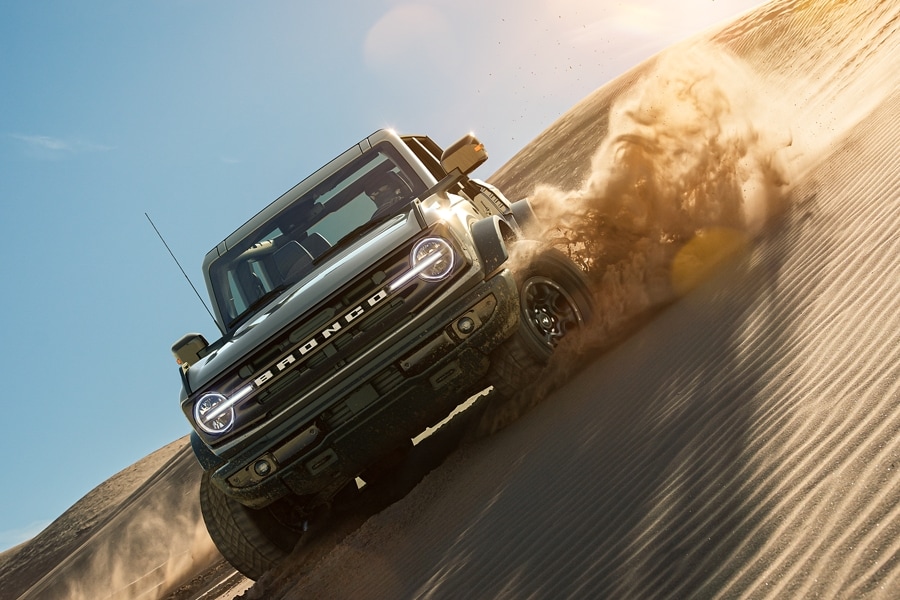 2021 Ford Bronco in Cactus Gray being driven on a sand dun