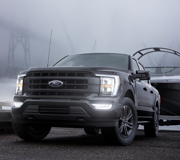 2022 Ford F-150® XLT in Agate Black backing a boat trailer into a lake
