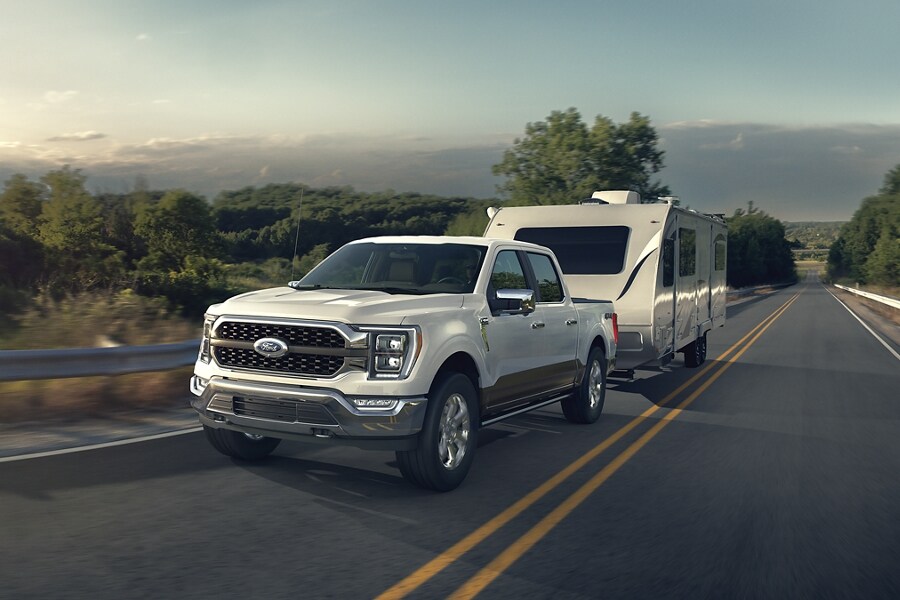2022 F-150® Platinum in Oxford White pulling a camper