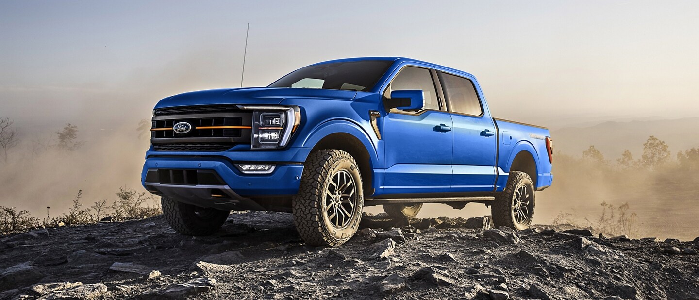 2022 Ford F-150® XLT SuperCrew® in Atlas Blue parked on a rocky hill