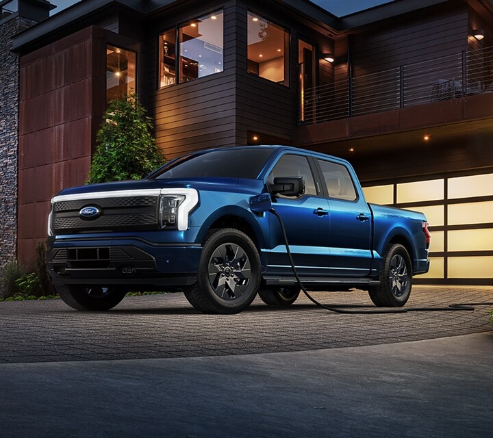 2022 Ford F-150® Lightning™ in Atlas Blue hooked up to a home charger