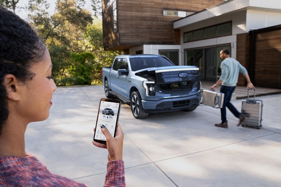 Close up of a woman using the Ford Pass app to open the front trunk of the Ford F-150® Lightning™