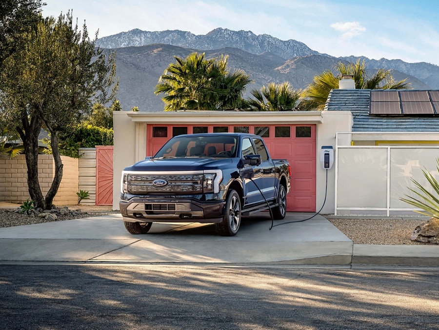A 2023 Ford F-150 Lightning® charging in a residential driveway