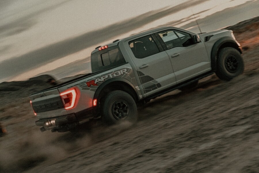 2023 Ford F-150® Raptor R™ being driven in the desert at dusk kicking up dust
