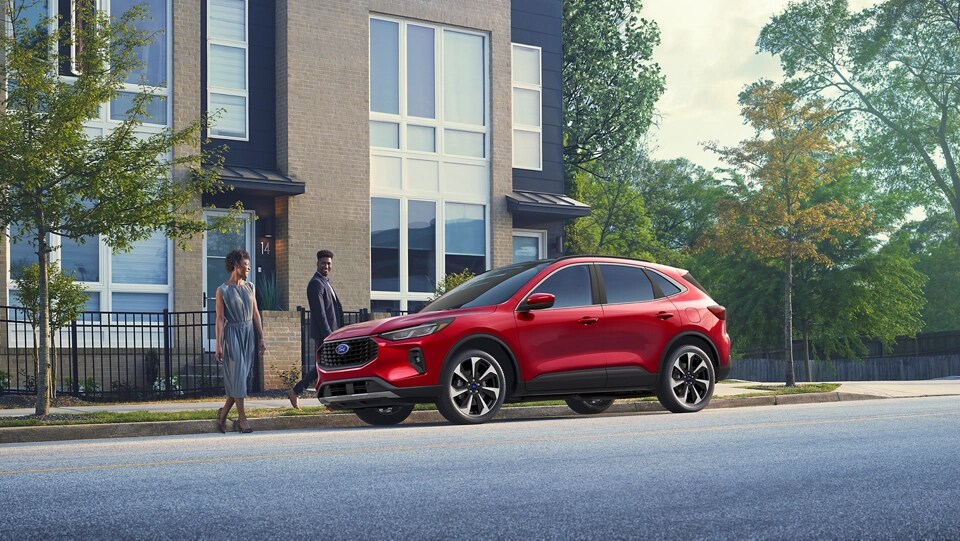 Deux personnes marchant jusqu’à un VUS Ford Escape® 2025 stationné dans une rue de la ville