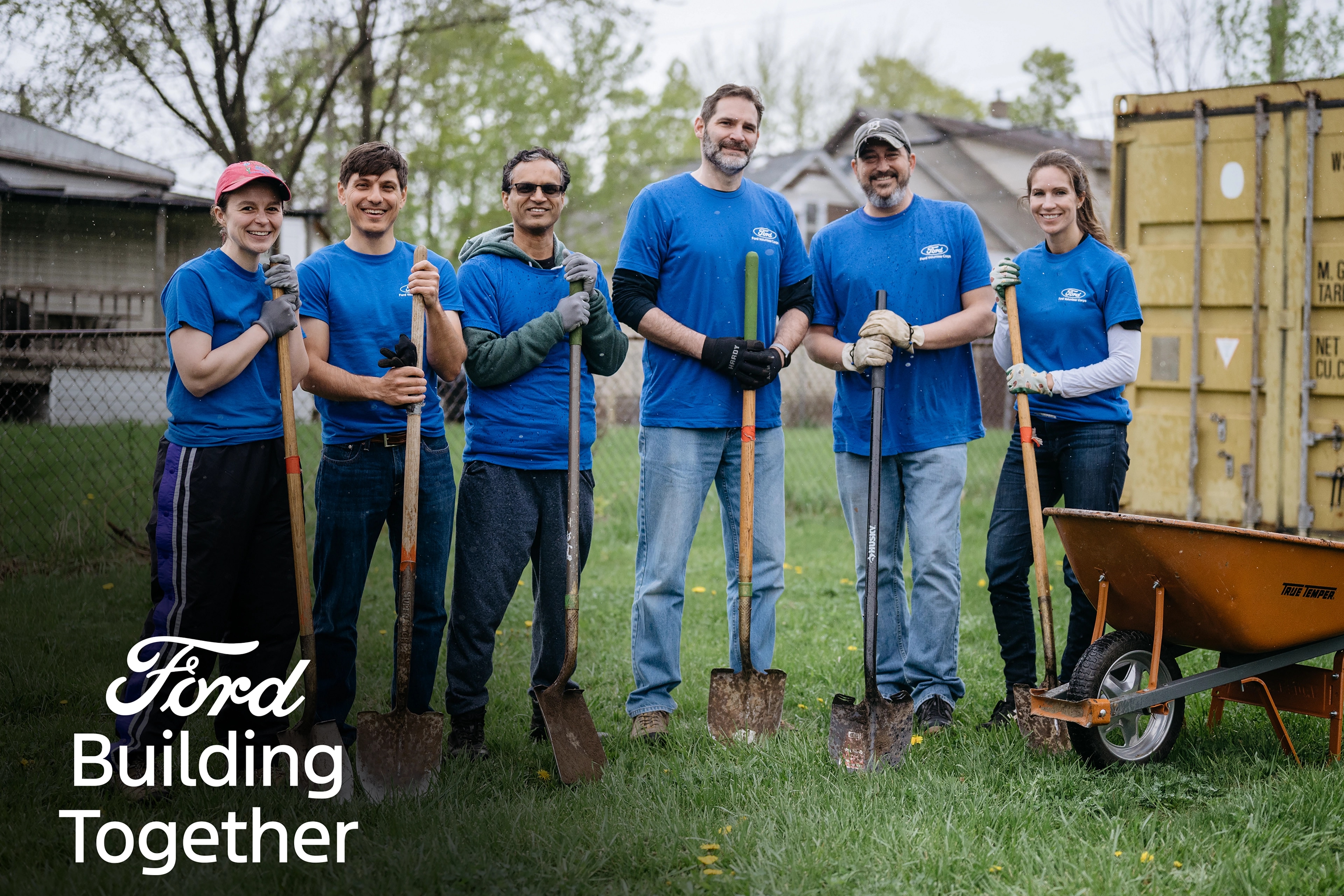 A group of people outside with shovels