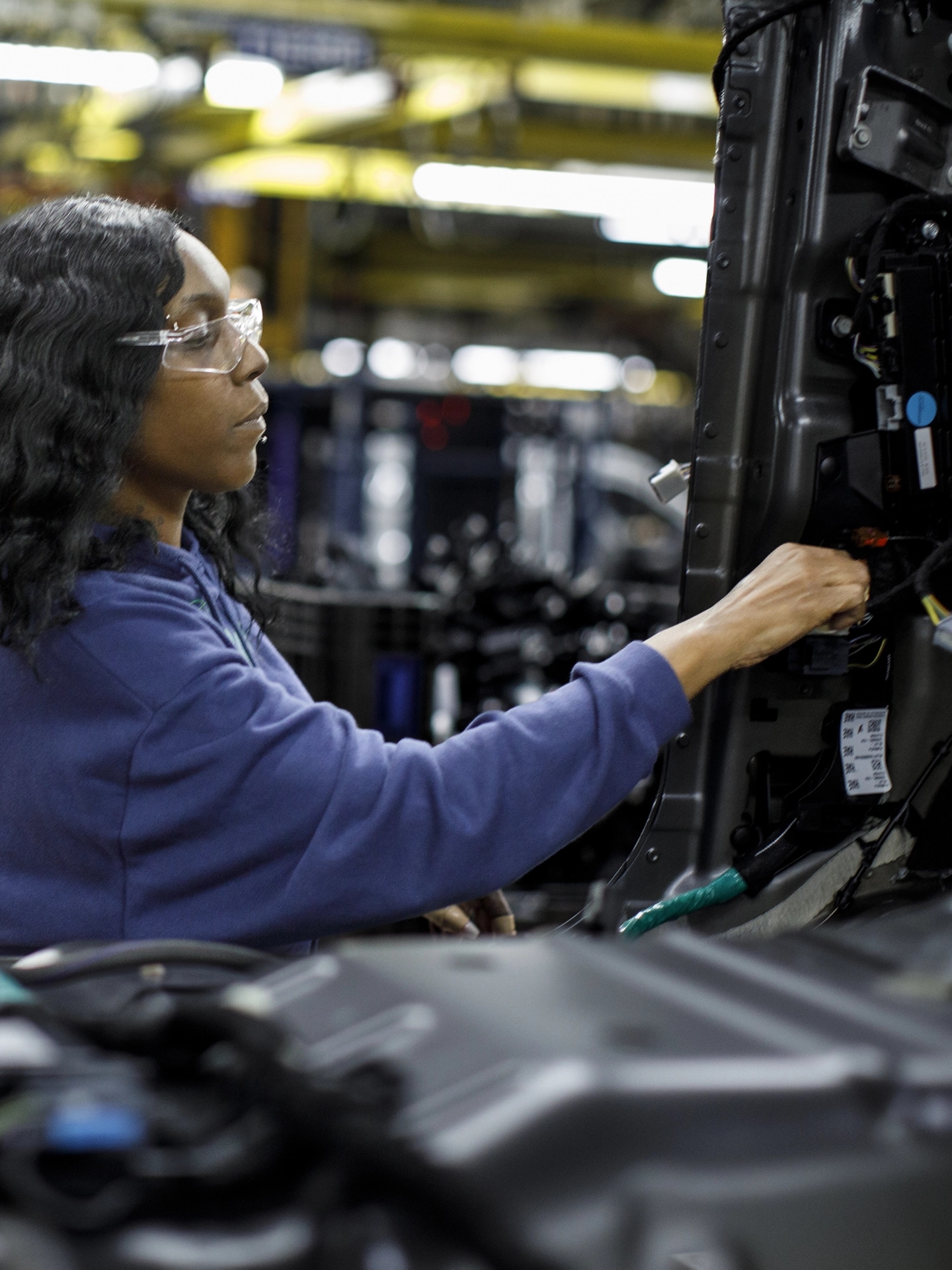A woman assembling a light in an assembly plant