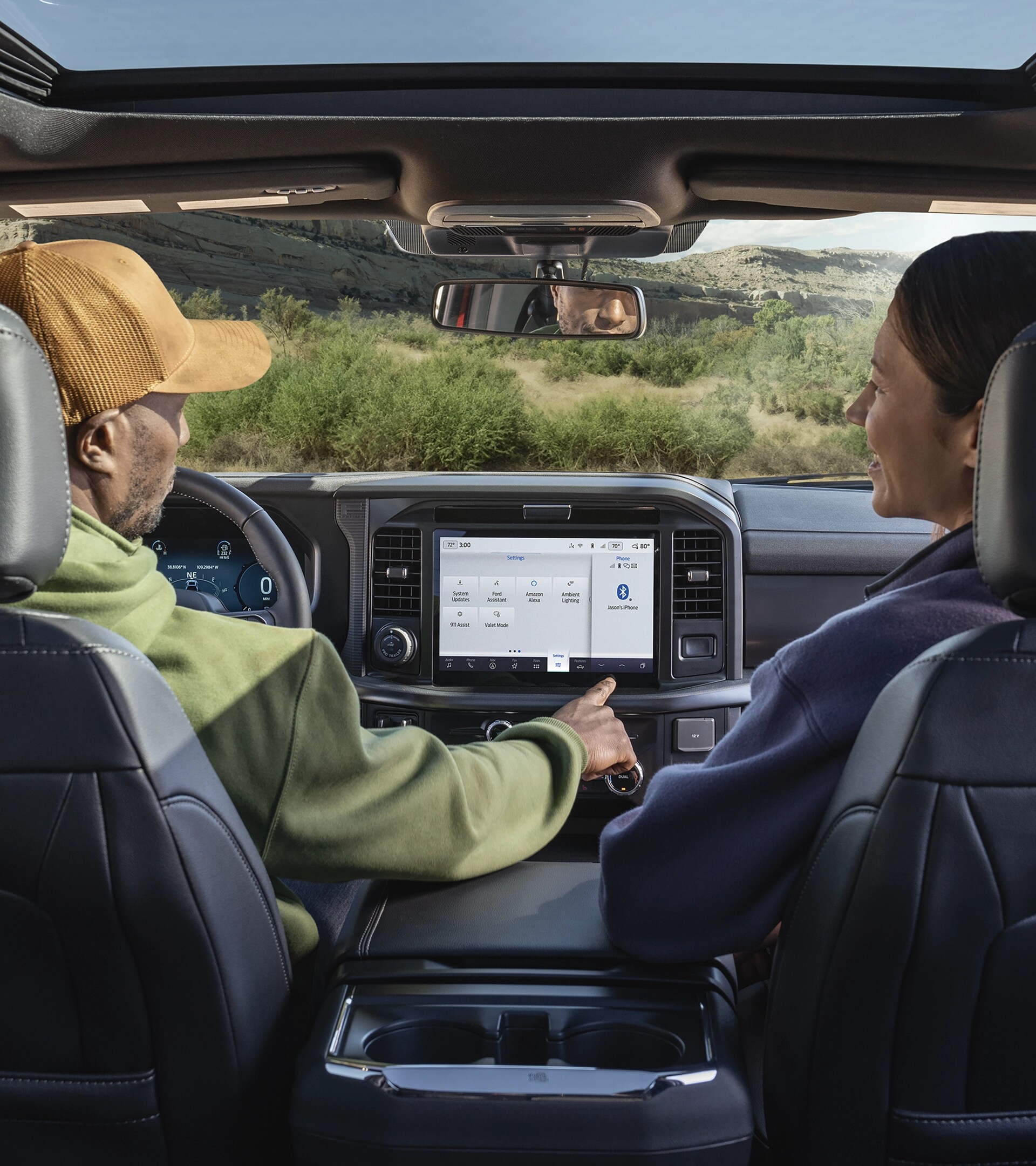 A man using the push-button features on the 12-inch center display with a woman seated in the passenger seat