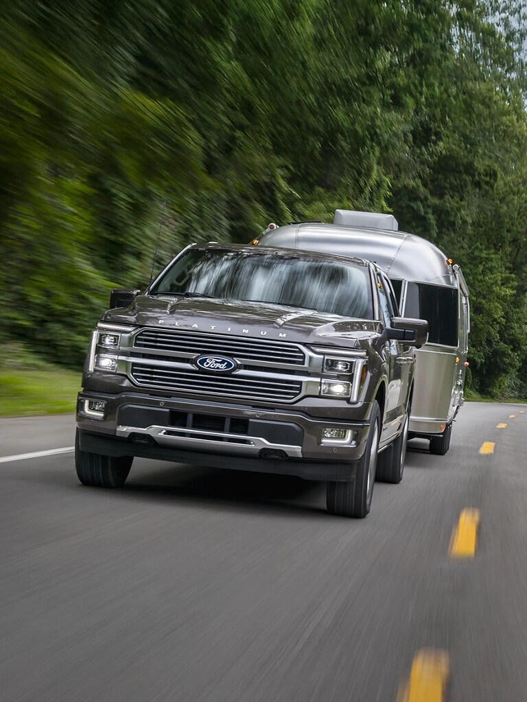 2026 Ford F-150® Platinum® truck in Marsh Gray pulling a camper