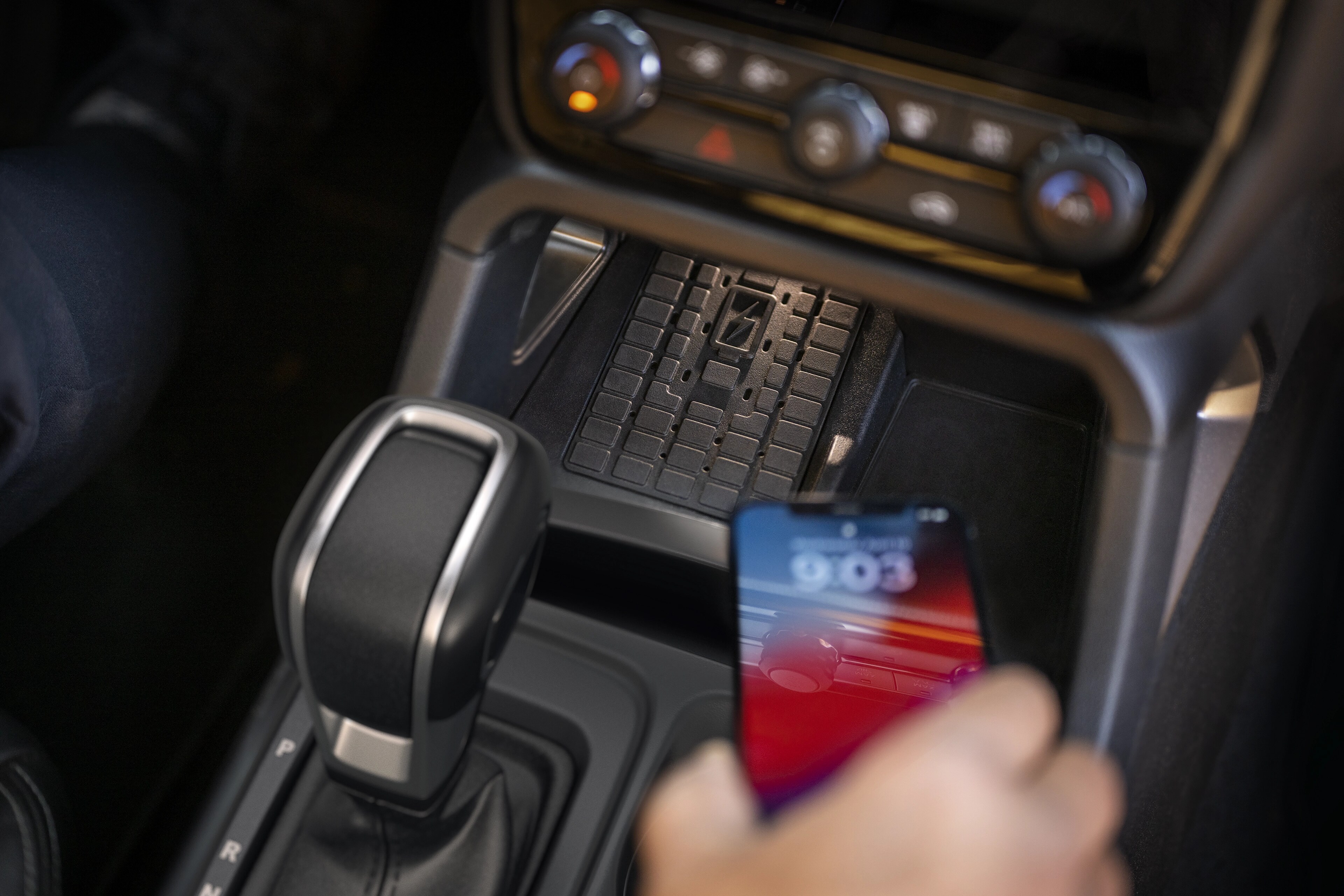 Close-up of a person placing a phone on the available wireless charger in the 2025 Ford Ranger®