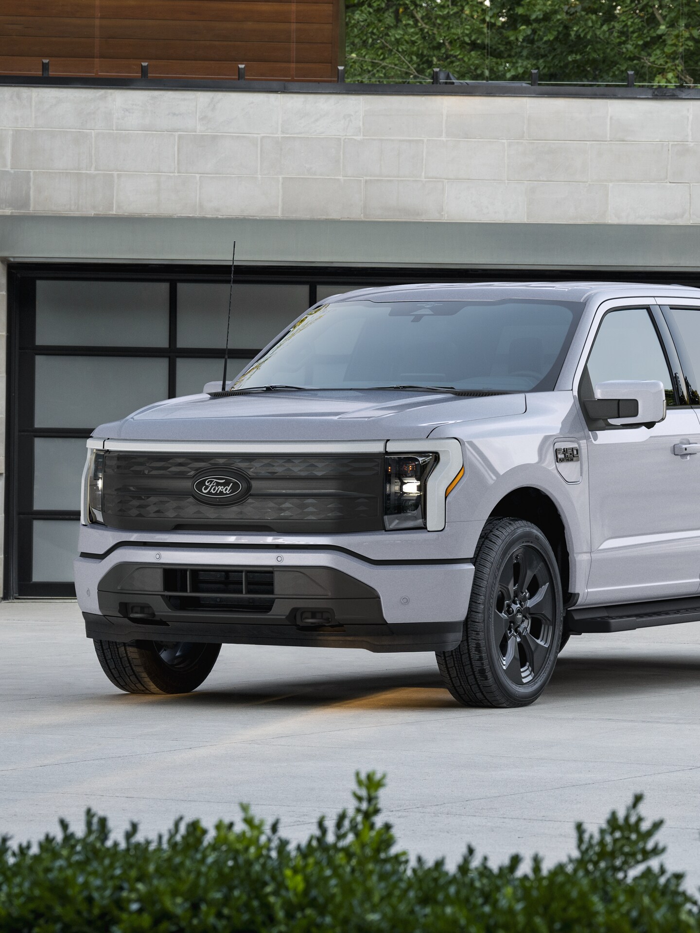 A 2025 Ford F-150® Lightning® parked in a driveway at dusk