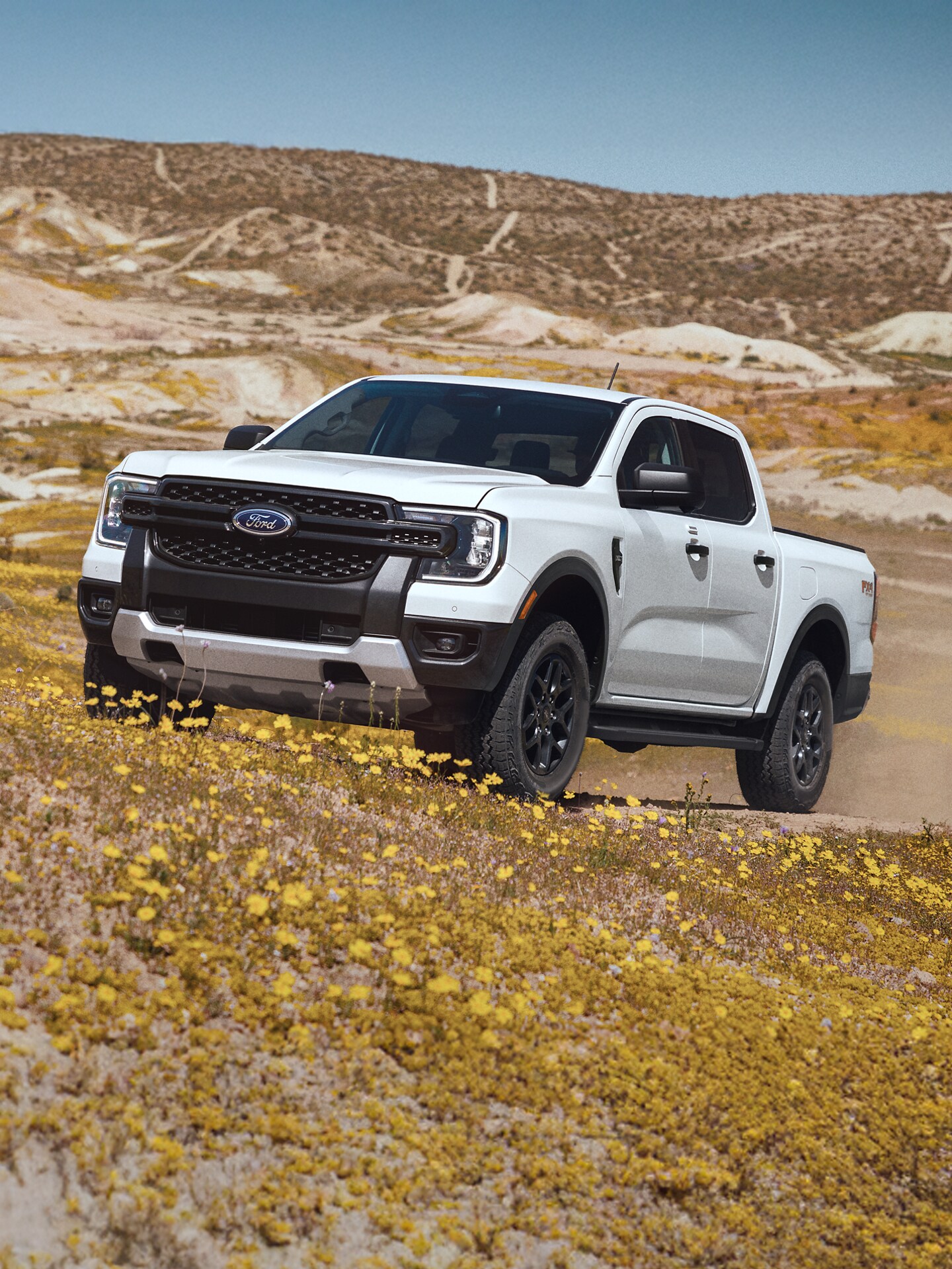 A 2025 Ford Ranger® ascends a sunny hillside trail