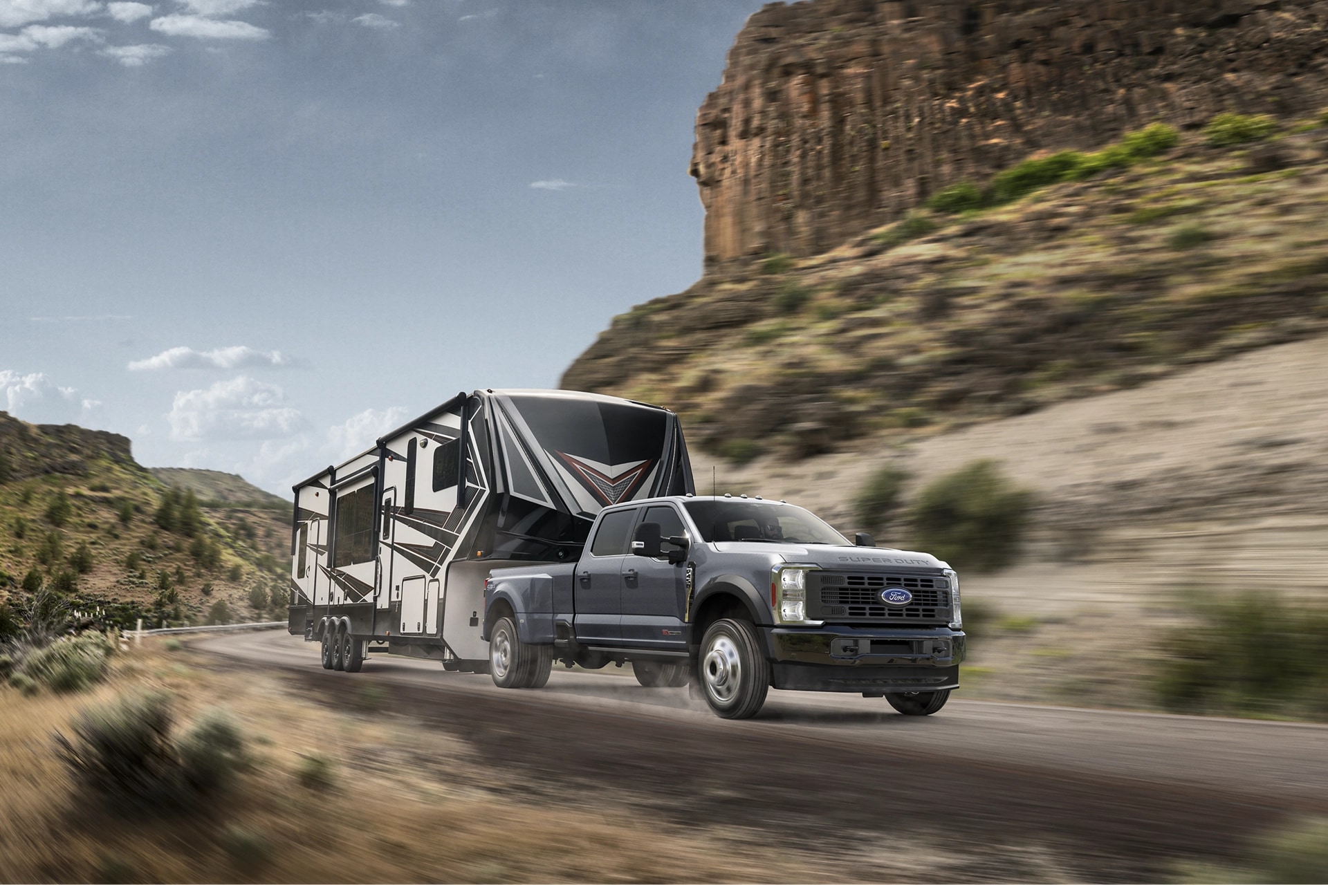 2025 Ford Super Duty® F-450® XL in Carbonized Gray pulling a camper down a winding road