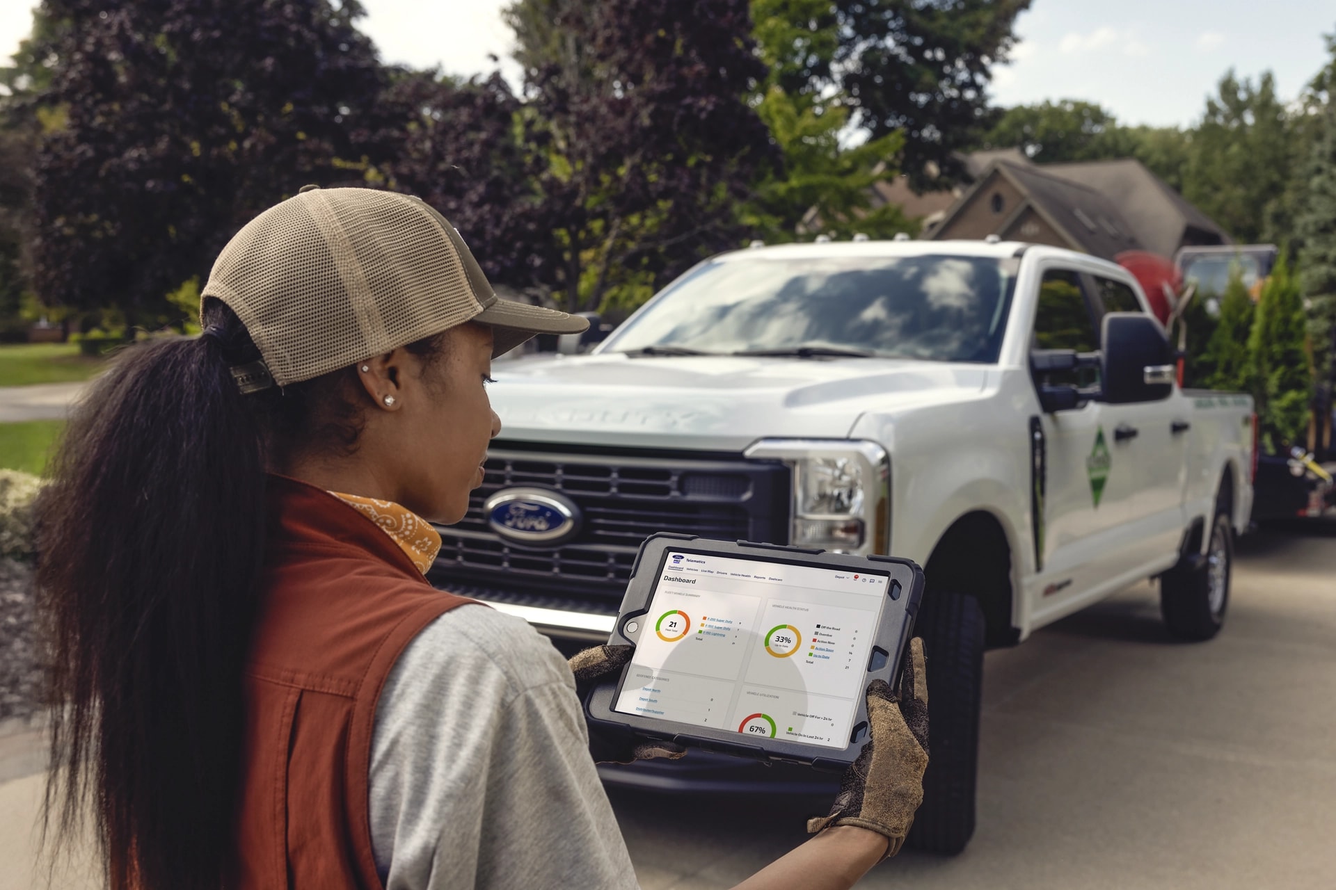 Woman looking at a tablet with a 2026 Ford Super Duty® pickup in the background