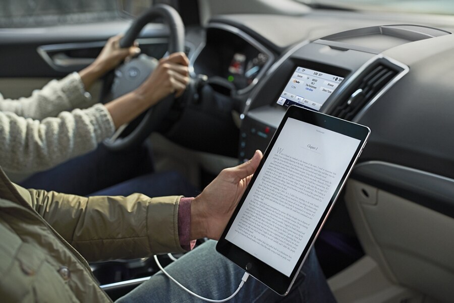 A driver and passenger using available in-vehicle Wi-Fi on a mobile device