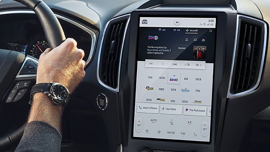 Driver in a vehicle with a touchscreen showing SiriusXM® with 360L