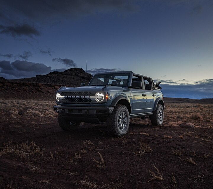  Four-door 2021 Ford® Bronco with doors and roof removed on mountain top at night