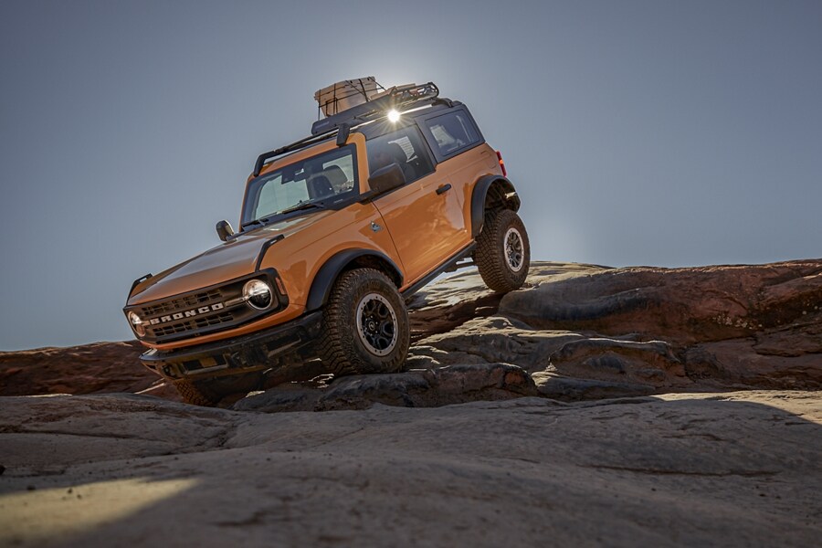 2021 Ford® Bronco two-door Black Diamond™ in cyber orange traversing rugged terrain