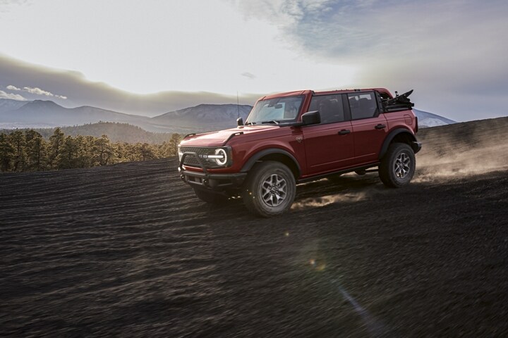 Una Ford Bronco® Badlands™ 2023 de 4 puertas en Race Red andando por las montañas