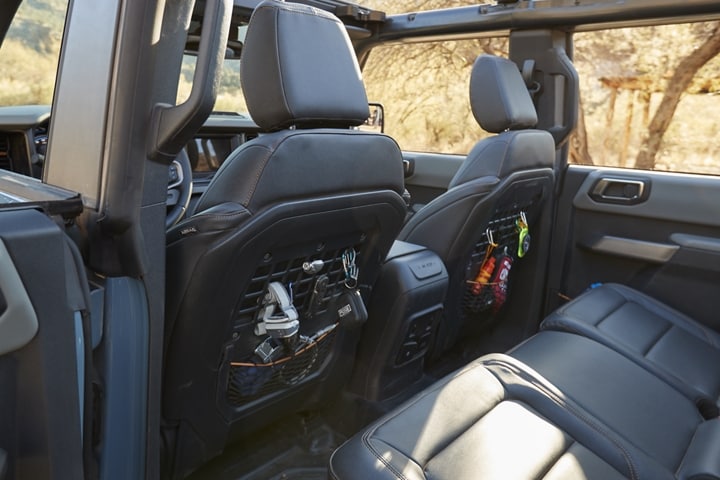 Se muestra el interior de una Ford Bronco® 2023 con asientos delanteros detrás del panel MOLLE